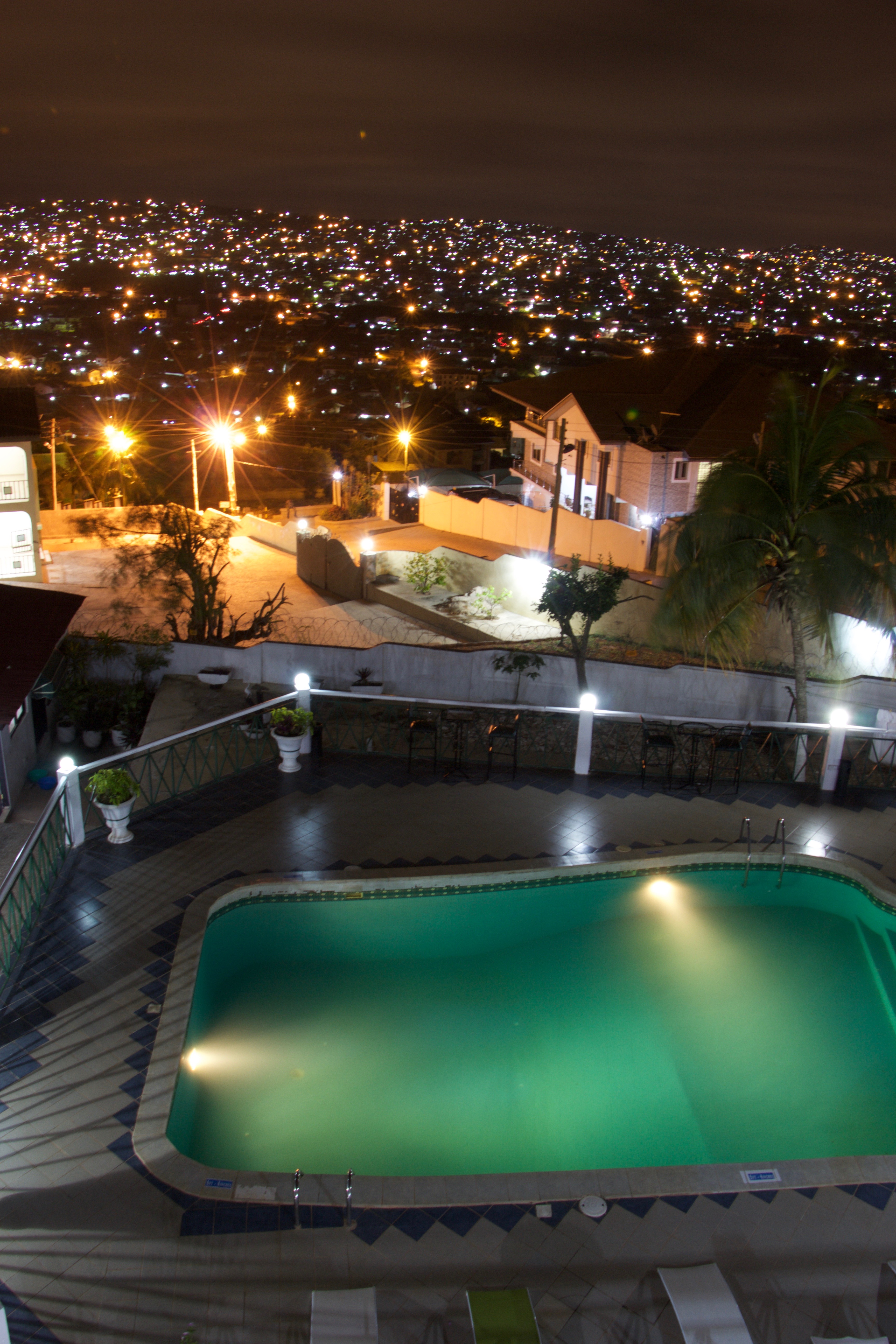 Illuminated pool with panoramic Accra city view at night
